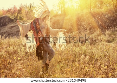 Beautiful girl in style of the American Indians dancing in the rays of the autumn sun. Western style. Jeans fashion.