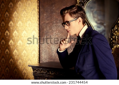 Handsome respectable man in elegant suit stands in a room with classic vintage style. Business. Fashion.