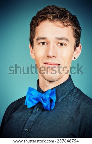 Close-up portrait of an imposing young man in formal shirt and bow-tie. Men\'s beauty, fashion.