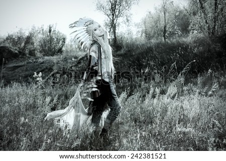 Fashion shot of a beautiful girl in style of the American Indians. Western style. Jeans fashion. Toned photo.