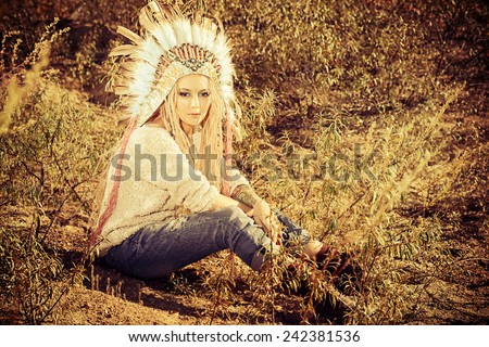 Fashion shot of a beautiful girl in style of the American Indians. Western style. Jeans fashion.