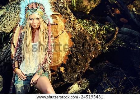 Attractive modern girl in style of the American Indians. Western style. Jeans fashion. Tattoo.
