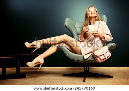 Portrait of a beautiful fashionable model sitting in a chair in Art Nouveau style. Interior, furniture.