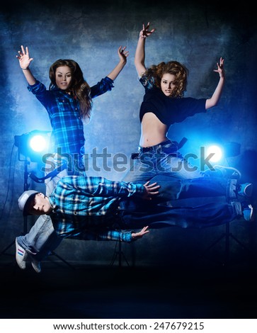 Group of modern dancers over grunge background. Urban, disco style.