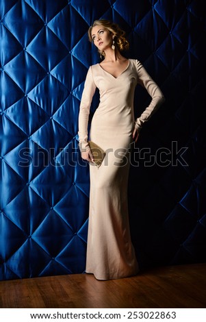 Full length portrait of a beautiful woman in elegant evening dress posing over vintage background. Jewellery.  Fashion shot. Hairstyle.