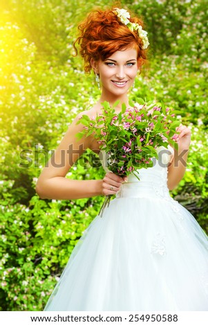 Beautiful smiling bride with chaming red hair. Wedding dress and accessories. Wedding decoration.