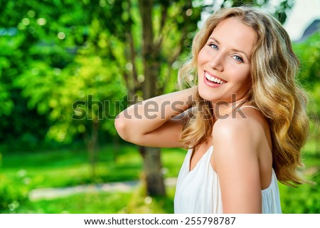 Close-up portrait of a  gorgeous young woman smiling at camera. Outdoor.