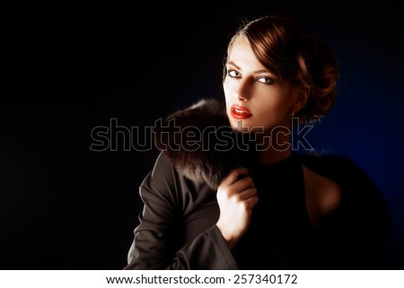 Glamorous young woman with evening make-up over dark background. Luxury. Beauty, fashion. Make-up.