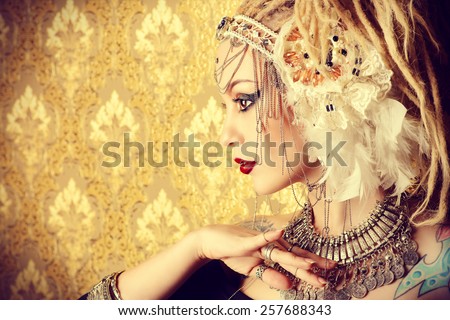 Close-up portrait of a magnificent traditional female dancer over golden vintage background. Ethnic dance. Belly dancing. Tribal dancing. Make-up, cosmetics.