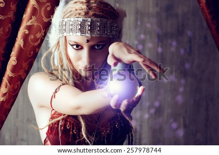 Magnificent fortune teller holding crystal ball. Magic.