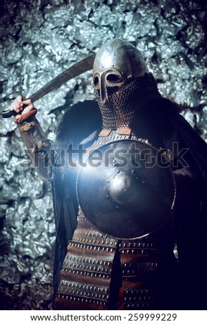 Ancient male warrior in armor holding sword and shield. Historical character. Fantasy.