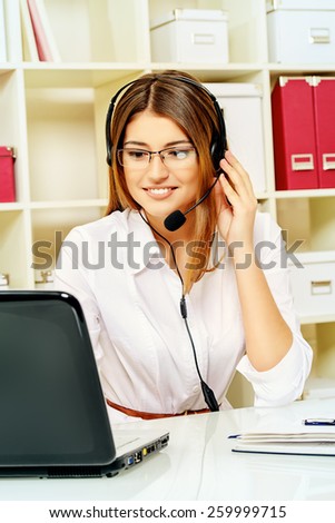 Happy smiling young woman surrort phone operator at her workplace in the office. Headset. Customer service.