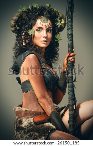 Fairy female Faun with a magic stick. Myth and fantasy. Body painting project. Studio shot.