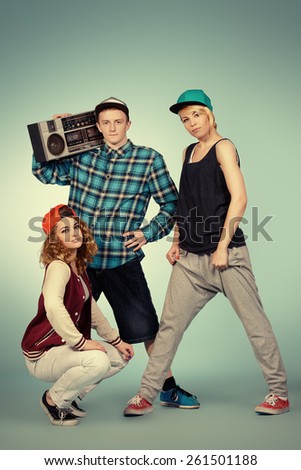 Group of young modern dancers dancing together with fun. Studio shot.