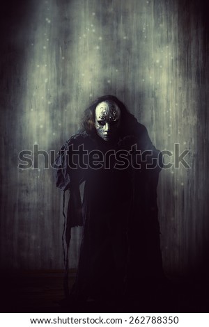 Scary man in iron mask and black robe. Fantasy. Halloween.