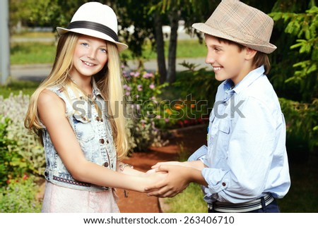 Two cheerful teenagers in the summer park. Friendship.