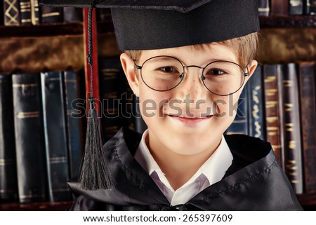 Smart boy stands in the library by the bookshelves with many old books. Educational concept. Science. Vintage style.