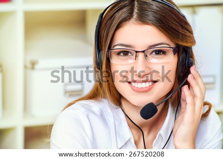Friendly smiling young woman surrort phone operator at her workplace in the office. Headset. Customer service.