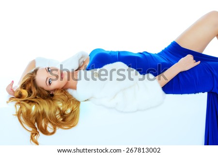 Stunning young woman posing in fashionable dress and mink fur jacket. Luxury, rich lifestyle. Fashion shot. Isolated over white background.