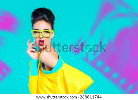 Expressive fashion model posing in vivid colourful clothes. Bright fashion. Optics, eyewear. Studio shot.