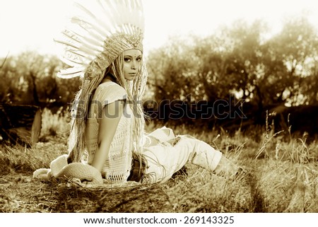 Fashion shot of a beautiful girl in style of the American Indians. Western style. Jeans fashion.