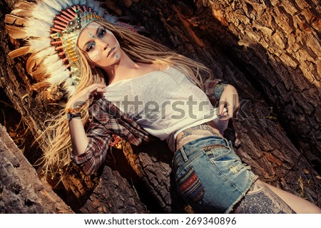 Attractive modern girl in style of the American Indians. Western style. Jeans fashion. Tattoo.