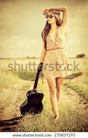 Romantic girl travelling with her guitar. Summer. Hippie style.