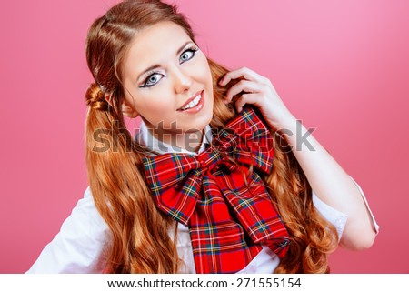 Portrait of a pretty smiling teen girl in school uniform posing over pink background. Anime style.