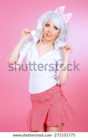 Lovely teen girl wearing white wig and school uniform posing over pink background. Anime style.