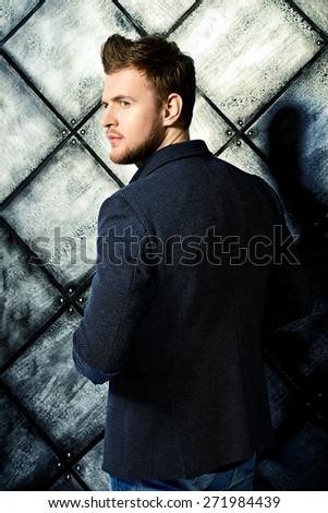 Vogue shot of a handsome man in black suit posing at studio. Men\'s beauty, fashion.
