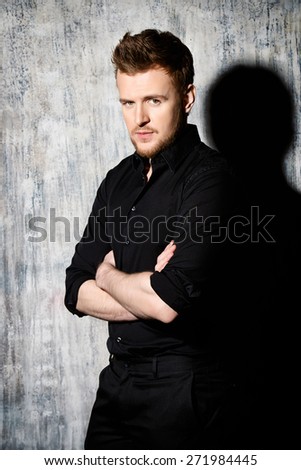 Fashionable man in black shirt posing at studio. Men\'s beauty, fashion.