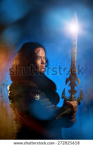 Ancient male warrior in armor holding sword. Historical character. Fantasy.