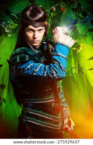 Beautiful warrior elf with a dagger in his hand in the magic forest. Fantasy. Fairy tale, magic.