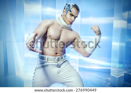 Portrait of a handsome muscular man with perfect body and futuristic make-up and hairstyle demonstrating his strength. Future generation.