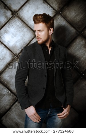 Vogue shot of a handsome man in black suit posing at studio. Men\'s beauty, fashion.