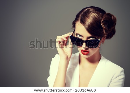 Close-up portrait of a gorgeous young woman wearing retro glasses. Beauty, fashion. Make-up. Optics, eyewear.