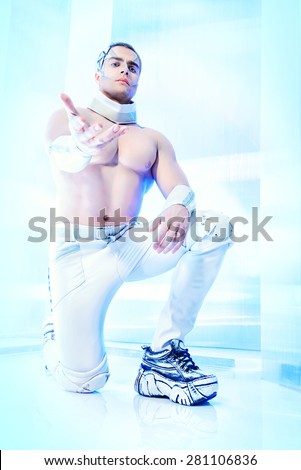 Technologies of the future, man of the future. Handsome muscular man with futuristic make-up stands on a luminous transparent background and stretches out his hand forward.