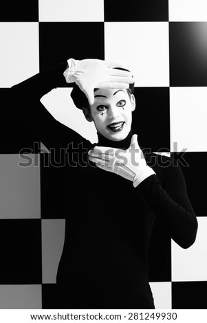 Professional mime artist performing different emotions. Chess board background.
