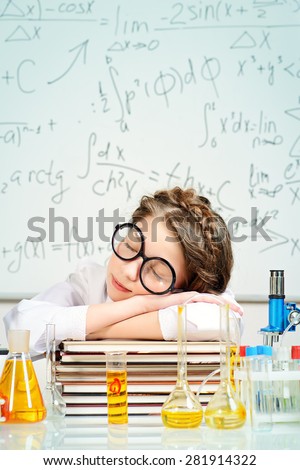 Tired girl fell asleep doing research in the laboratory. Science and education.