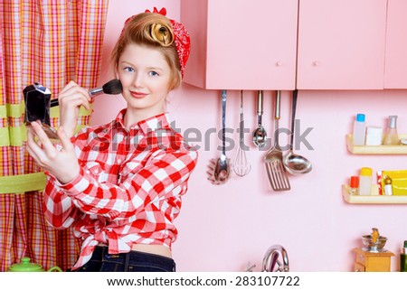 Pretty pin-up girl teenager smarten up on a pink kitchen. Beauty, youth fashion. Pin-up style.