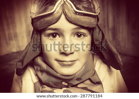 Close-up portrait of a boy who dreams of becoming a pilot. Childhood. Fantasy, imagination. Retro style.