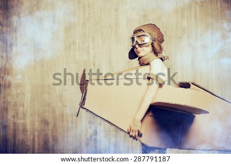 Cute dreamer boy playing with a cardboard airplane. Childhood. Fantasy, imagination. Retro style.