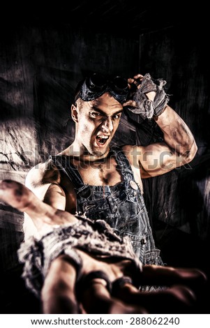 Brutal muscular dirty man expressing aggression over dark grunge background. Mining industry. World of the future, Apocalypse.