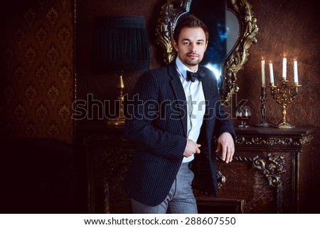 Handsome elegant young man in classic vintage apartments. Fashion. Luxury.