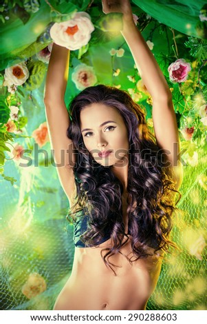 Beautiful brunette woman in bikini among tropical plants. Beauty, fashion. Spa, healthcare. Tropical vacation.