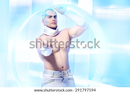 Futuristic handsome man with perfect muscular body stands on a luminous transparent background. Technology. Future concept.