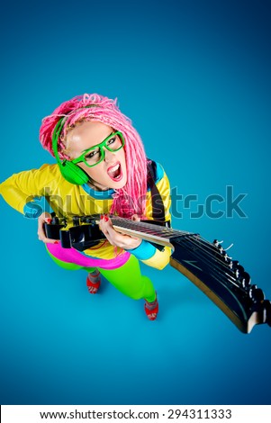 Female rock star playing the electric guitar. Bright style. Show business.