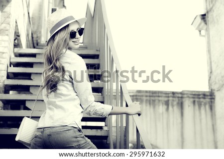Beautiful young woman walking in the city. Fashion. Black-and-white photo.
