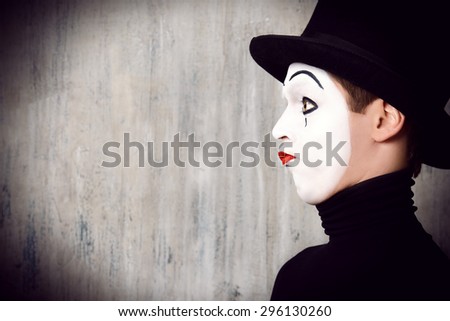 Portrait in profile of a male mime artist performing different emotions. Grunge background.