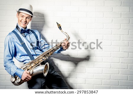 Young expressive musician playing the saxophone. Art and music. Jazz music.